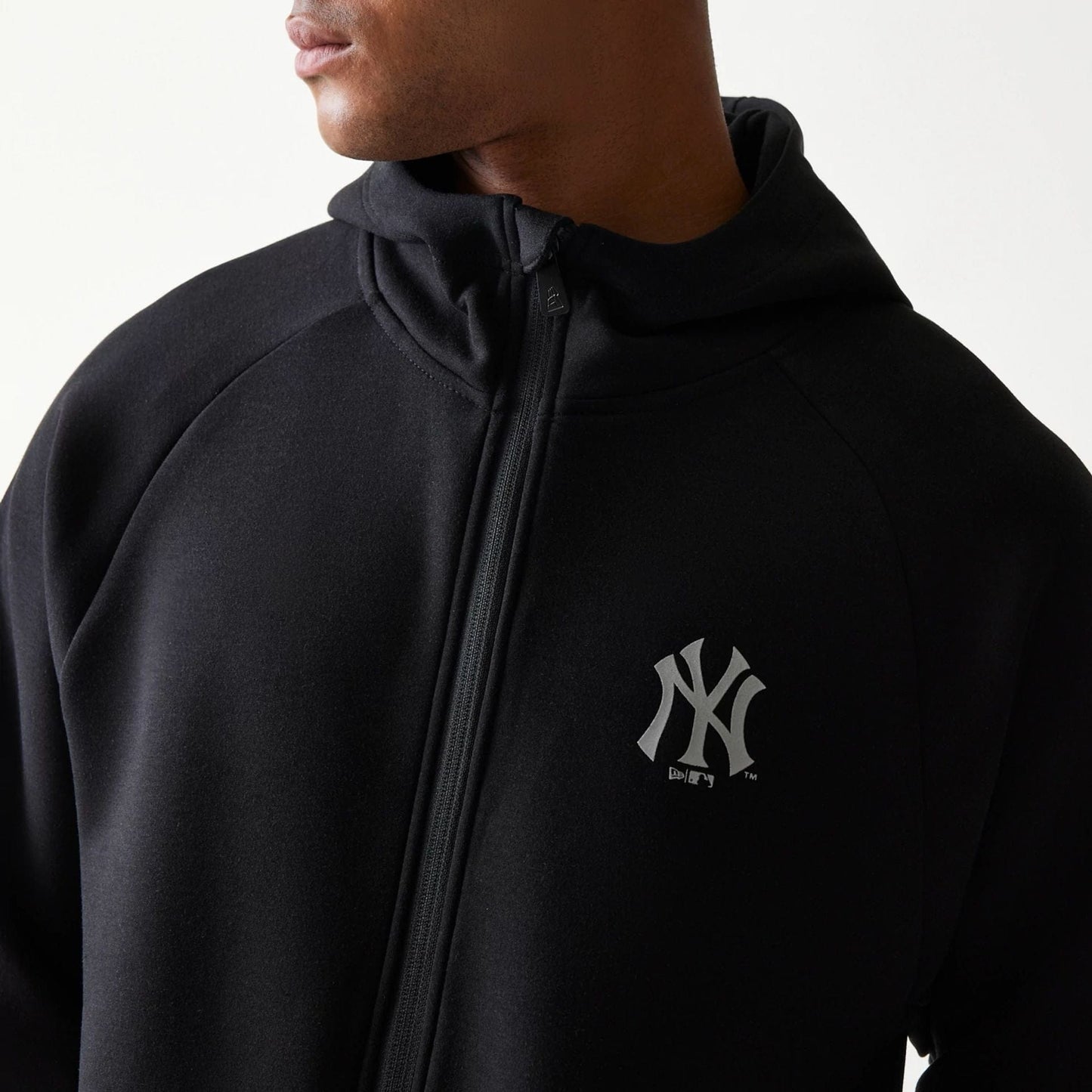 The model is wearing this MLB New York Yankees Full Zip Hoodie in black. 4