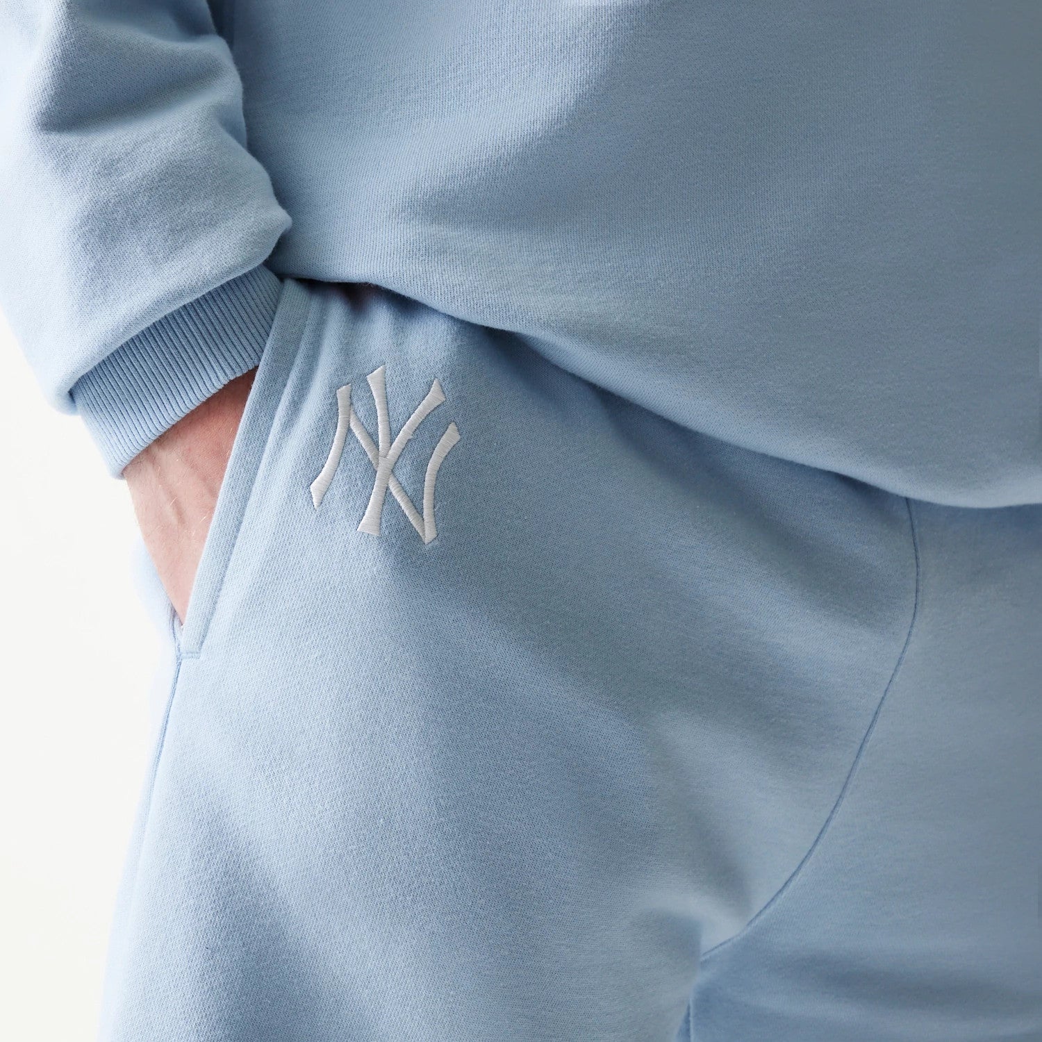 The model is wearing this MLB League Essential Midi New York Yankees Shorts in blue. 4