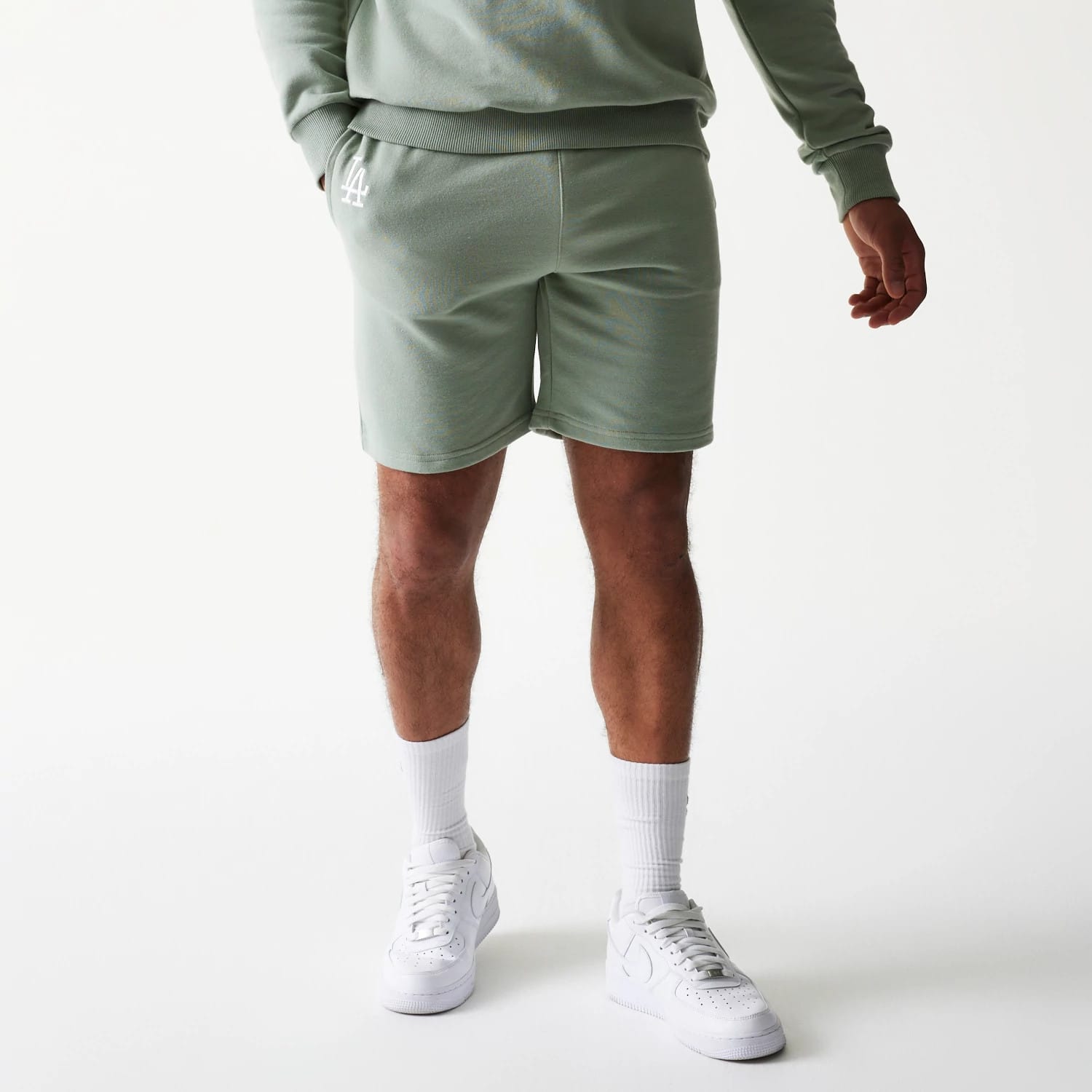The model is wearing this MLB League Essential Midi LA Dodgers Shorts in green. 1
