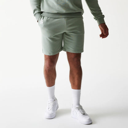 The model is wearing this MLB League Essential Midi LA Dodgers Shorts in green. 1