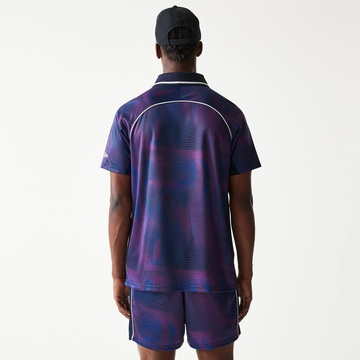New Era Red Bull Racing All Over Print Dark Blue Football T-Shirt, back view on a model showing the dark blue and purple pattern with light piping detail across the shoulders and sleeves, paired with matching shorts.