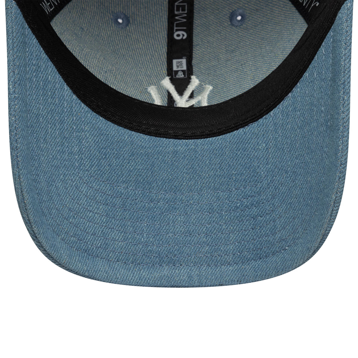 New York Yankees Womens MLB Denim Stitch Pastel Blue New Era 9TWENTY Cap, inside view showing the white embroidered NY logo set against a black sweatband, with black taping and a denim undervisor contrasting the pastel blue crown.