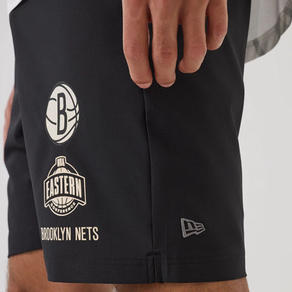 The model is wearing this NBA Match Brooklyn Nets Oversized Shorts in black. 5