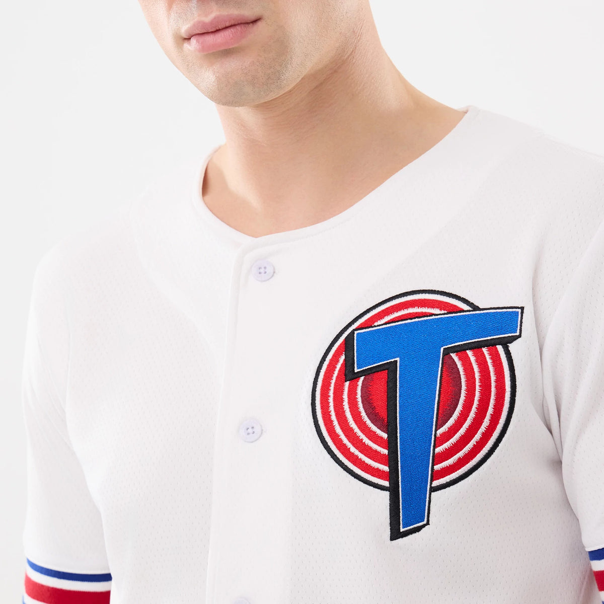 New Era Space Jam Warner Brothers Space Jam White Mesh Jersey, front view on a model showing the large embroidered blue and red T logo on the front with button fastening and blue and red stripes on the sleeves.