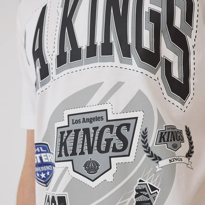 New Era LA Kings NHL Sport Classic White T-Shirt, front view displaying large black and grey LA Kings lettering across the chest with multiple graphic patches and logos, including an embroidered crest reading Los Angeles Kings.