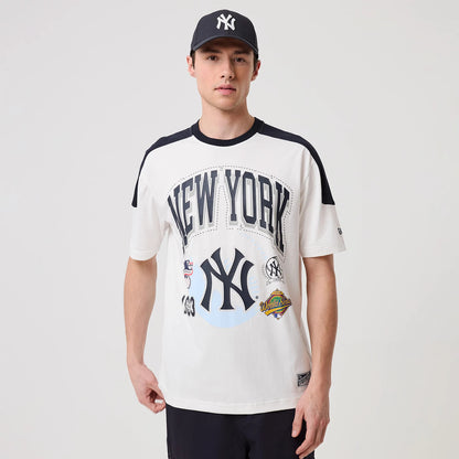 New Era New York Yankees MLB Sport Classic World Series White T-Shirt, front view on-model featuring large printed New York lettering across the chest, Yankees logo below, and colourful World Series patches near the hem.
