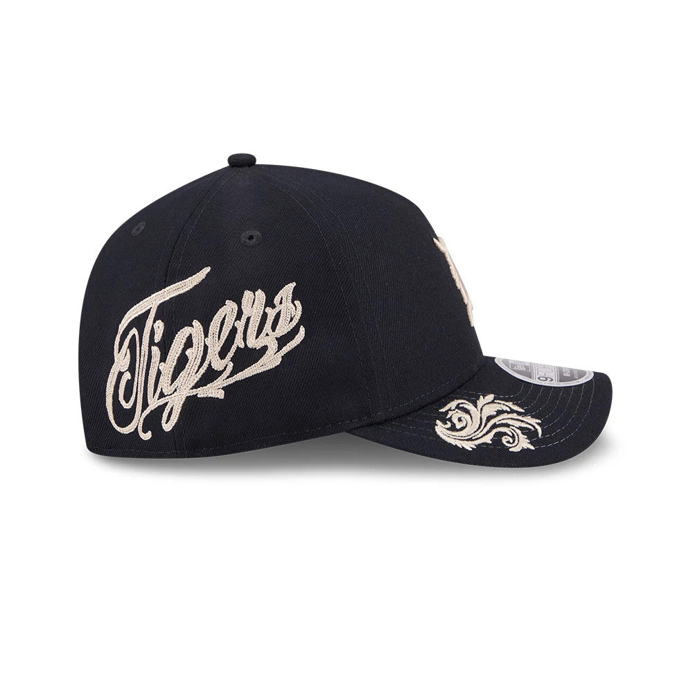 Detroit Tigers MLB Script Navy New Era 9FORTY M-Crown A-Frame Adjustable Cap, side view showing a cream embroidered Tigers script on the navy crown and a decorative swirl on the visor with a 9FORTY size sticker.
