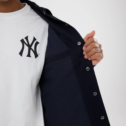 New Era New York Yankees MLB Script Navy Coach Jacket, front view showing the jacket partially open with silver popper buttons and the white embroidered New York Yankees logo on the inner shirt beneath.