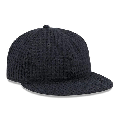 New Era Waffle Knit Navy Retro Crown 9FIFTY Adjustable Cap, front view showing textured waffle knit fabric on the structured navy crown and flat visor, with a top button and embroidered eyelets.