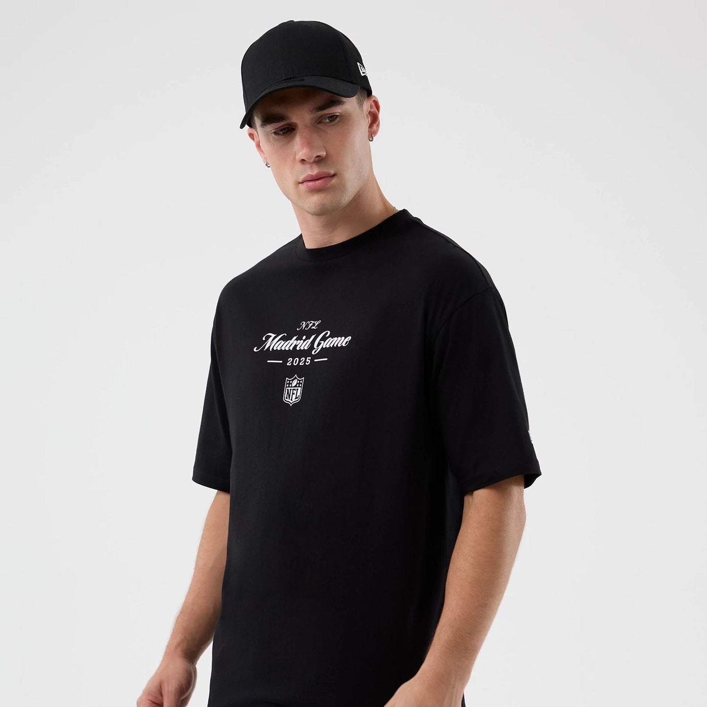 The Male model is wearing Madrid Game NFL International Series Games Black Oversized T-Shirt  4