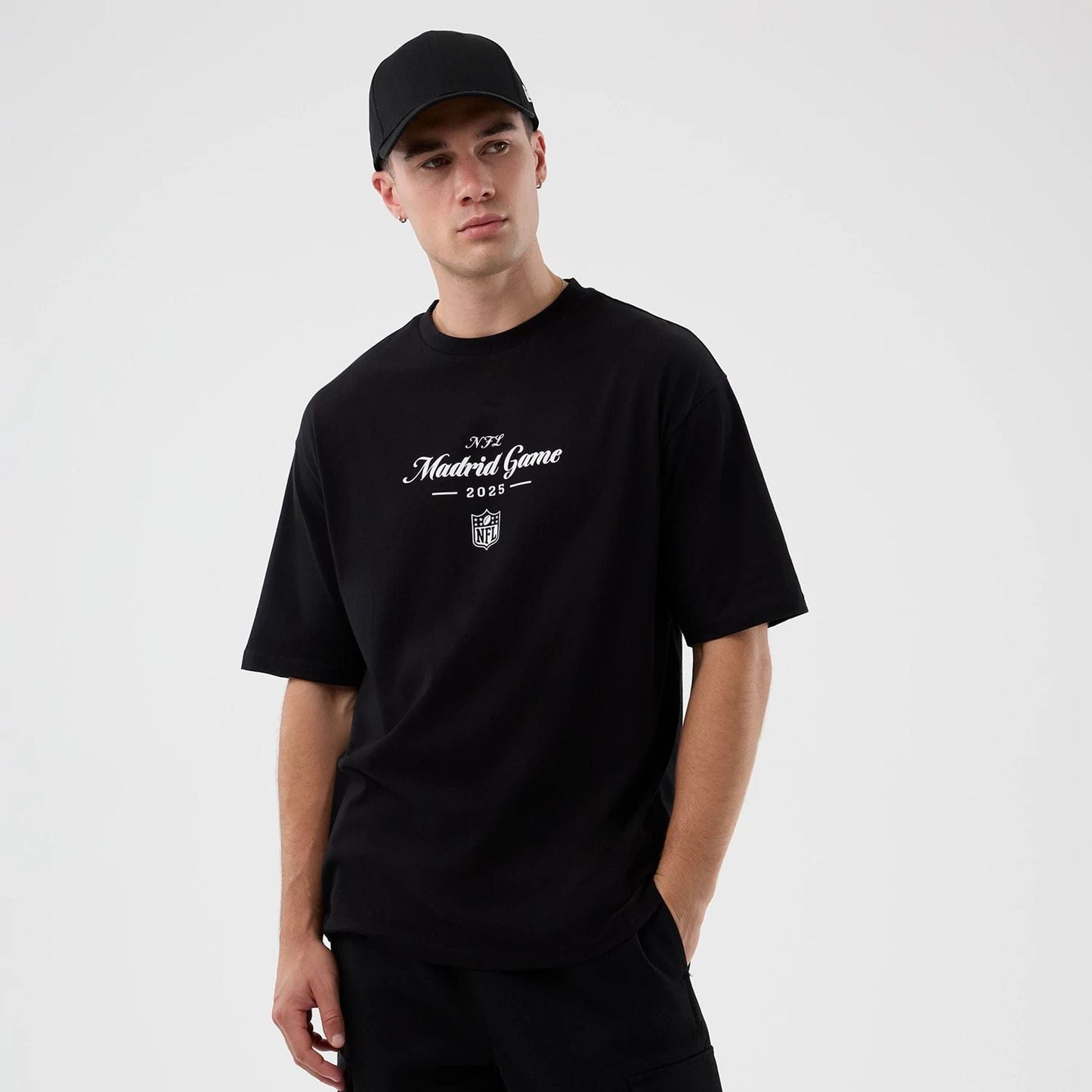The Male model is wearing Madrid Game NFL International Series Games Black Oversized T-Shirt  1