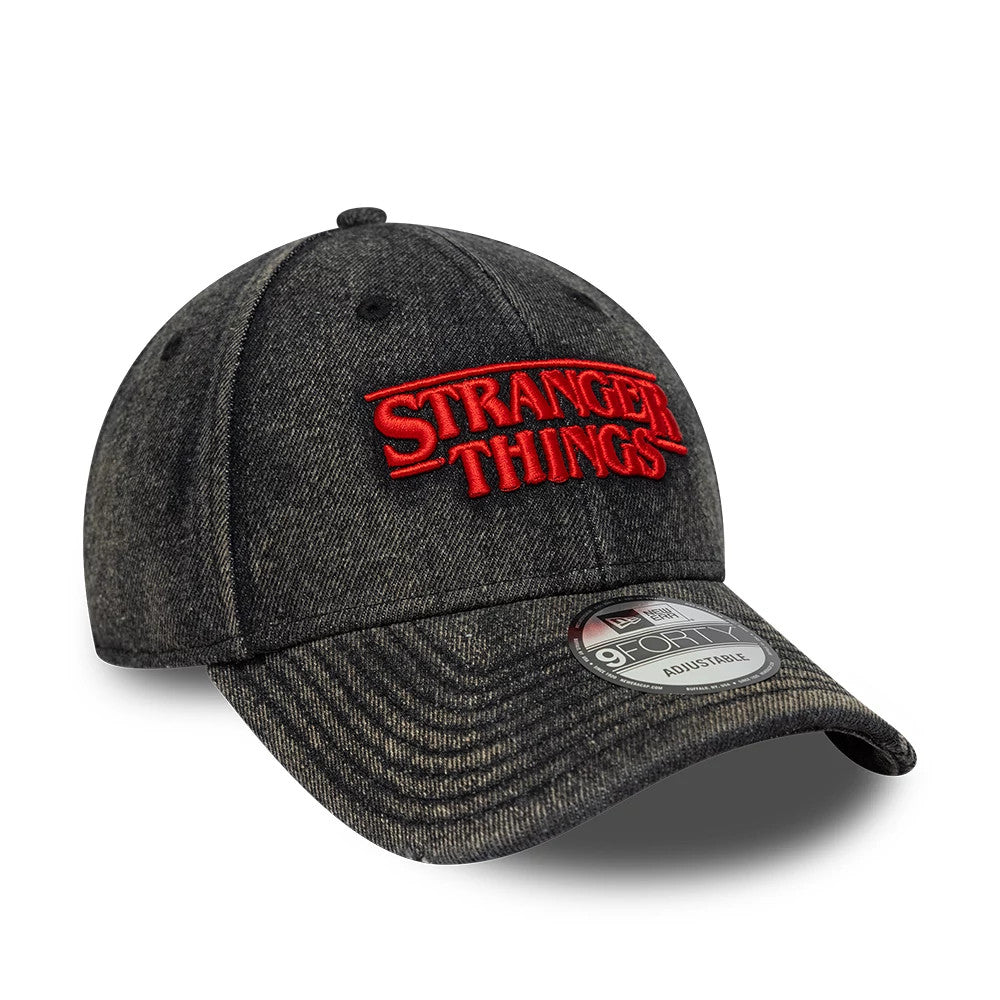 Stranger Things Distressed Black New Era 9FORTY Adjustable Cap, front view showing the red embroidered Stranger Things logo on the distressed black crown with a curved black visor and a 9FORTY size sticker.