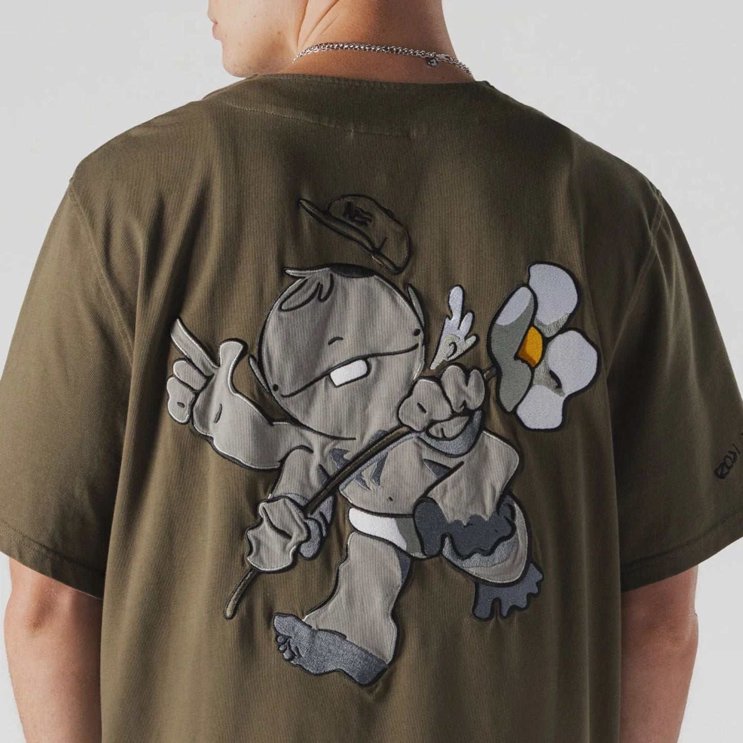 The Male model is wearing  New Era x Rodrigo Roji Flower Green Jersey  6