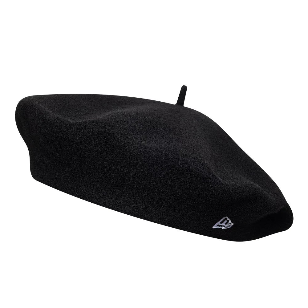 Womens New Era Wool Black Beret, three-quarter view showing the classic beret silhouette with a small top tab and a white embroidered New Era flag logo on the side, crafted from soft black wool.