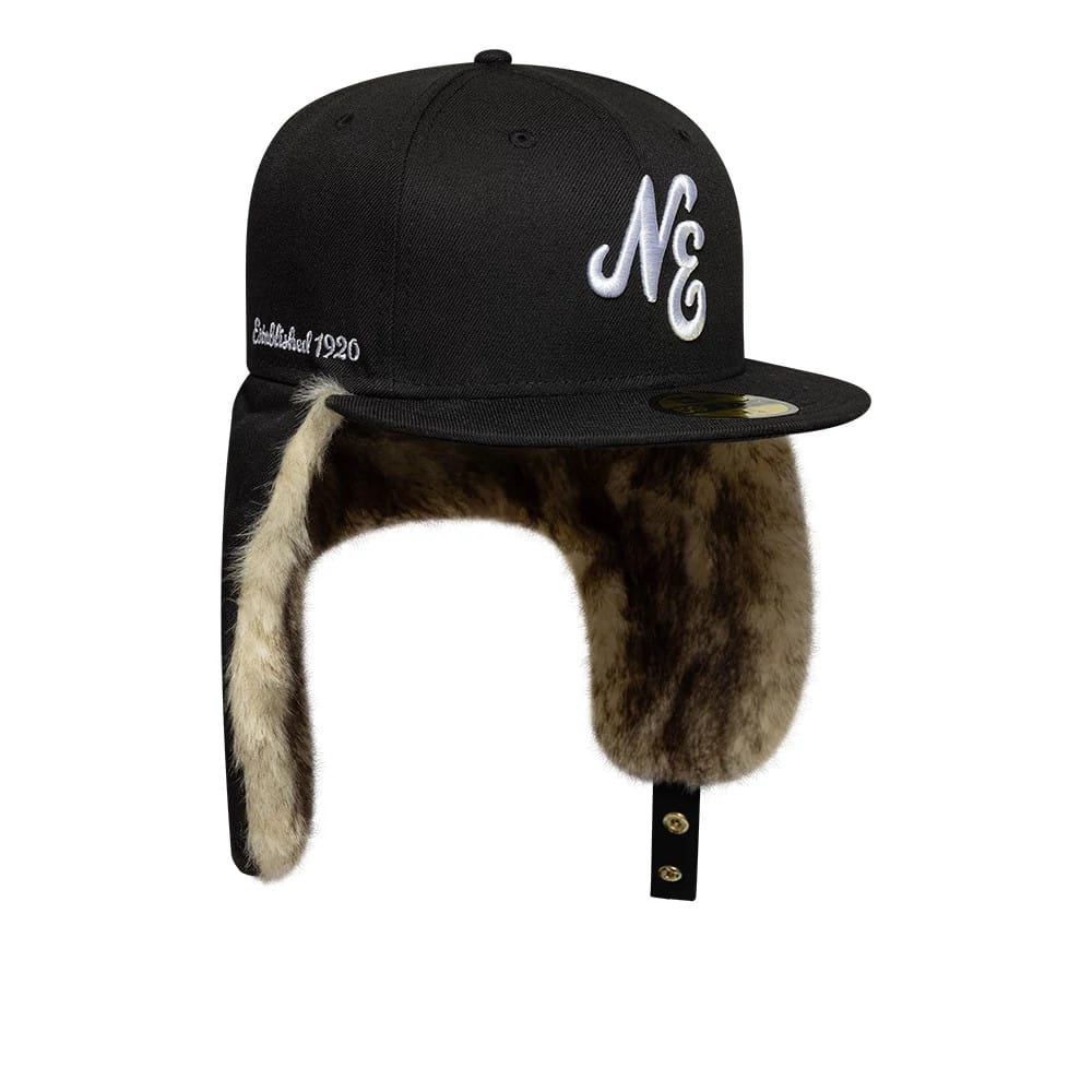 New Era Black Dogear 59FIFTY Fitted Cap, front three-quarter view showing raised white NE embroidery on the black front panel, black flat visor with gold 59FIFTY size sticker, and black faux fur-lined ear flaps.
