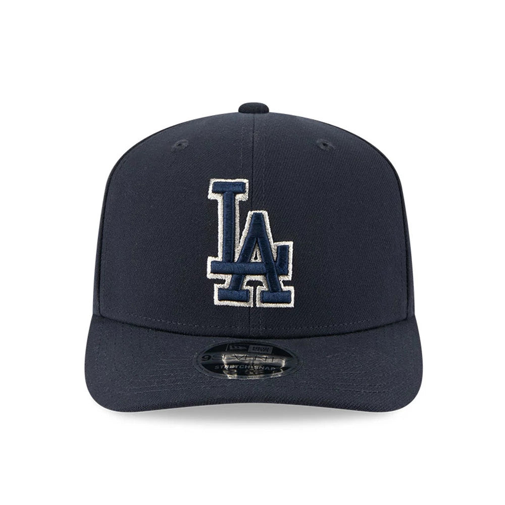 LA Dodgers MLB Navy New Era 9SEVENTY Stretch Snap Adjustable Cap, front view showing white outlined navy LA logo in raised embroidery on the structured crown, with a 9SEVENTY size sticker on the curved visor.