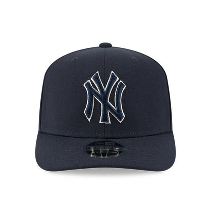 New York Yankees MLB Navy New Era 9SEVENTY Stretch Snap Adjustable Cap, front view showing the raised navy NY logo with white outline embroidered on the front panel, and a black 9SEVENTY size sticker on the curved navy visor.