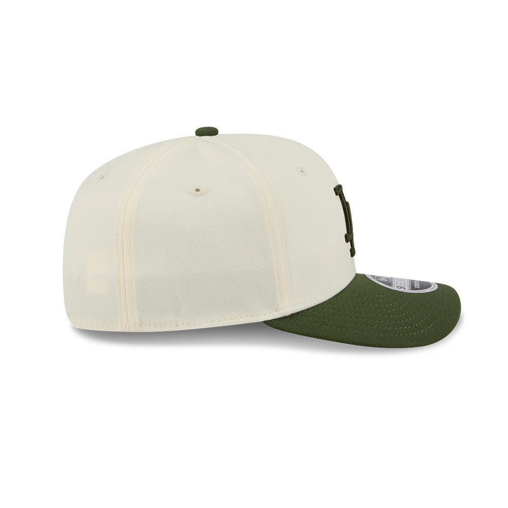 LA Dodgers MLB Rifle Green New Era 9SEVENTY Stretch Snap Adjustable Cap, side view showing the raised embroidered LA logo on the front panel, a contrasting rifle green curved visor with a 9SEVENTY size sticker, and green top button.