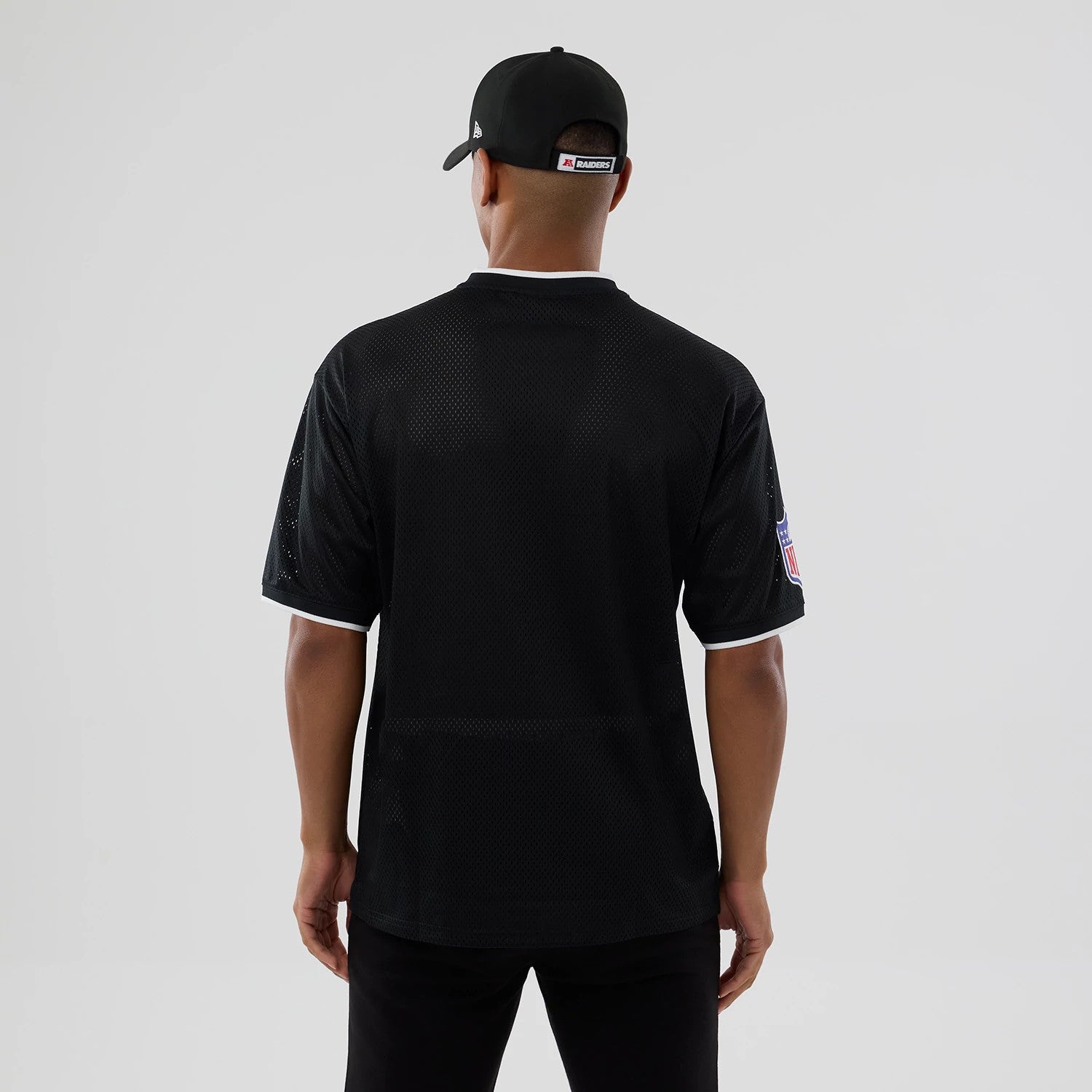 The model is wearing this NFL Mesh Las Vegas Raiders Oversized T-Shirt in black. 2