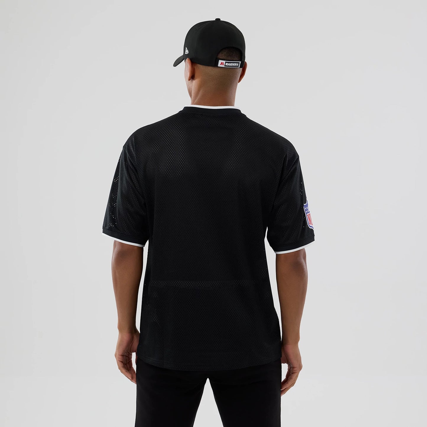 The model is wearing this NFL Mesh Las Vegas Raiders Oversized T-Shirt in black. 2