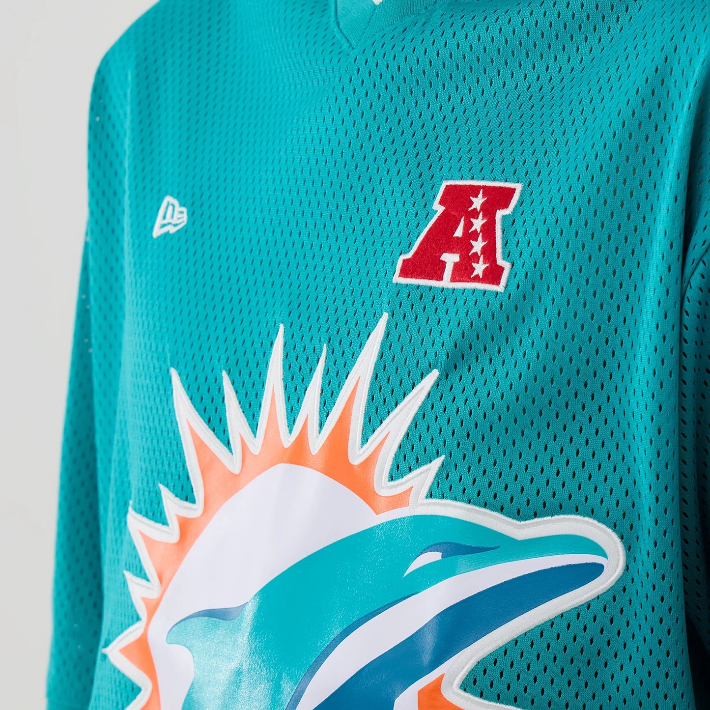 The model is wearing this NFL Mesh Miami Dolphins Oversized T-Shirt in turquoise. 4