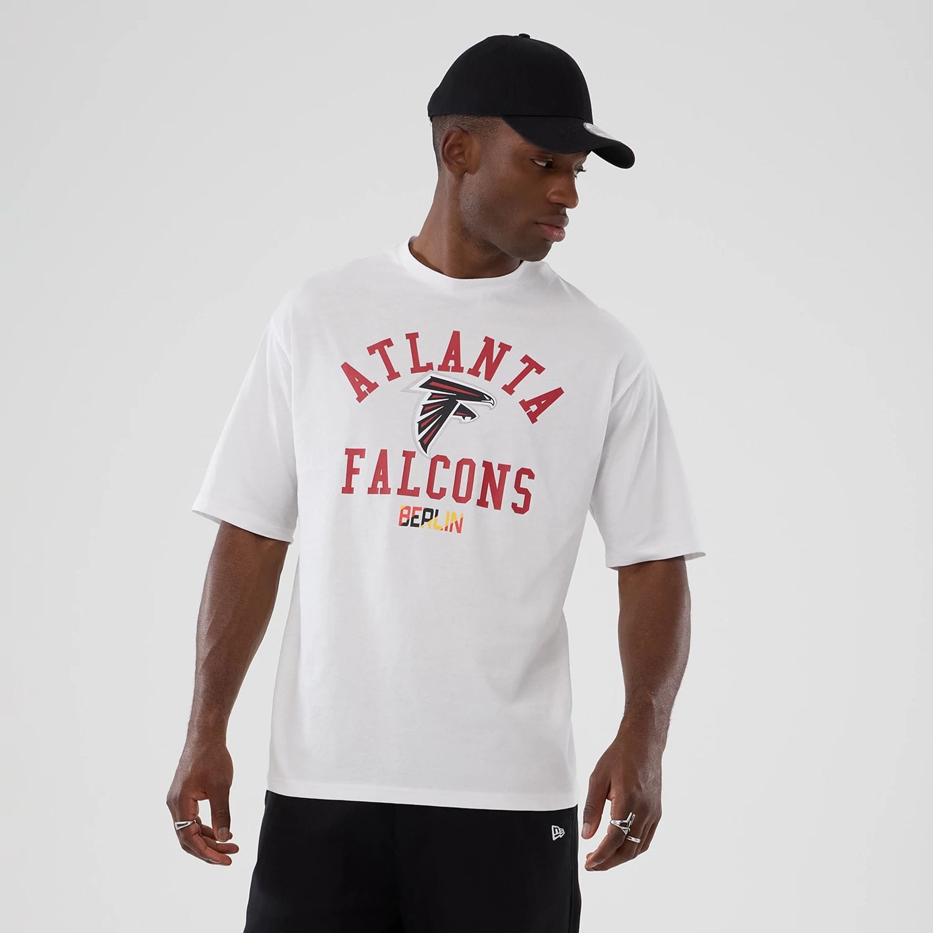 The Male model is wearing Atlanta Falcons NFL International Series Games 2025 White Oversized T-Shirt  7