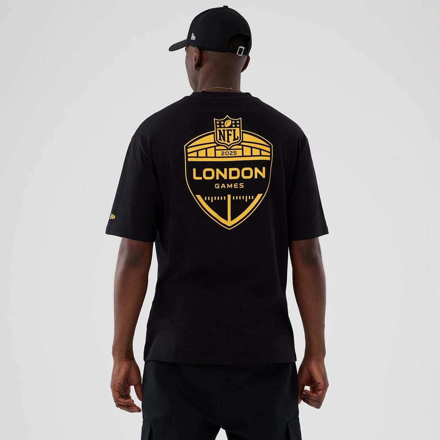 The Male model is wearing Minnesota Vikings NFL International Series Games 2025 Black Oversized T-Shirt  2