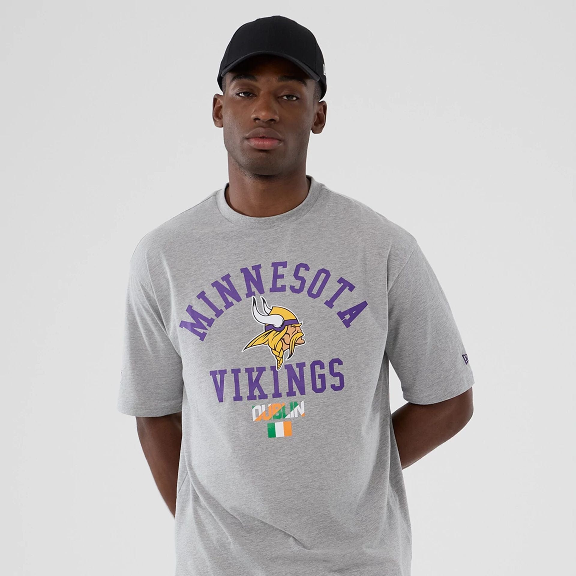 The Male model is wearing Minnesota Vikings NFL International Series Games 2025 Grey Oversized T-Shirt  7