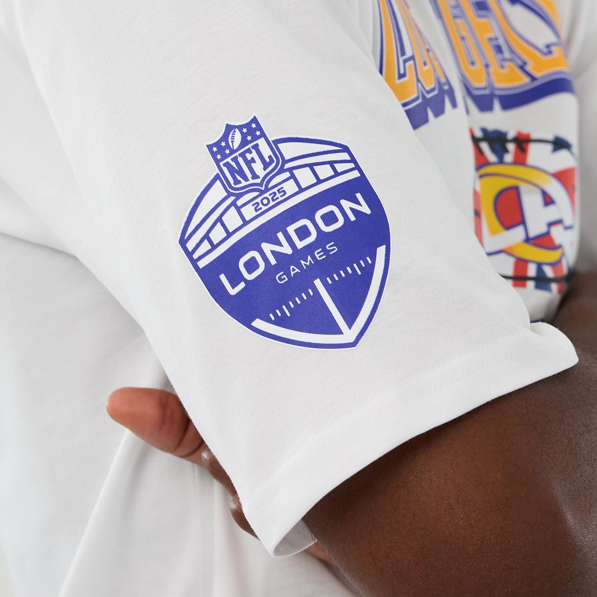 The Male model is wearing LA Rams NFL International Series Games 2025 White Oversized T-Shirt  4
