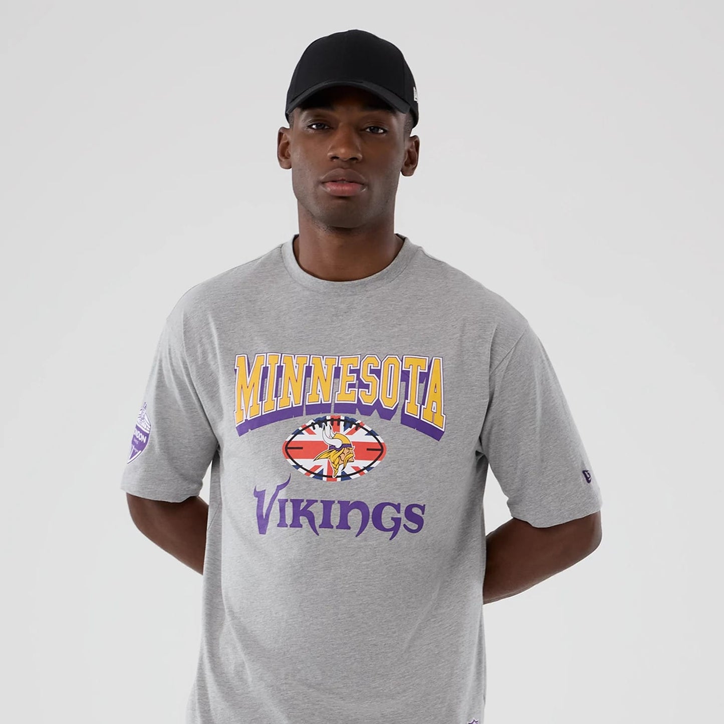 The Male model is wearing Minnesota Vikings NFL International Series Games 2025 Grey Oversized T-Shirt 3