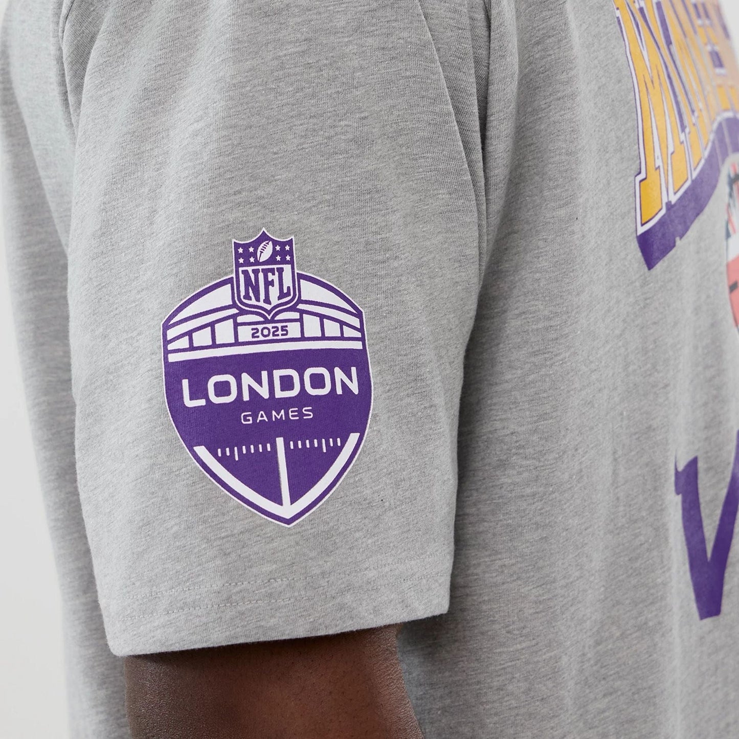 The Male model is wearing Minnesota Vikings NFL International Series Games 2025 Grey Oversized T-Shirt  4