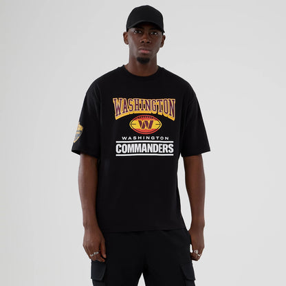 New Era Commanders NFL International Series Games Script 2025 Black Oversized T-Shirt, front view showing Washington and Commanders lettering in yellow and white across the chest, with a team logo graphic and printed details on the sleeve.