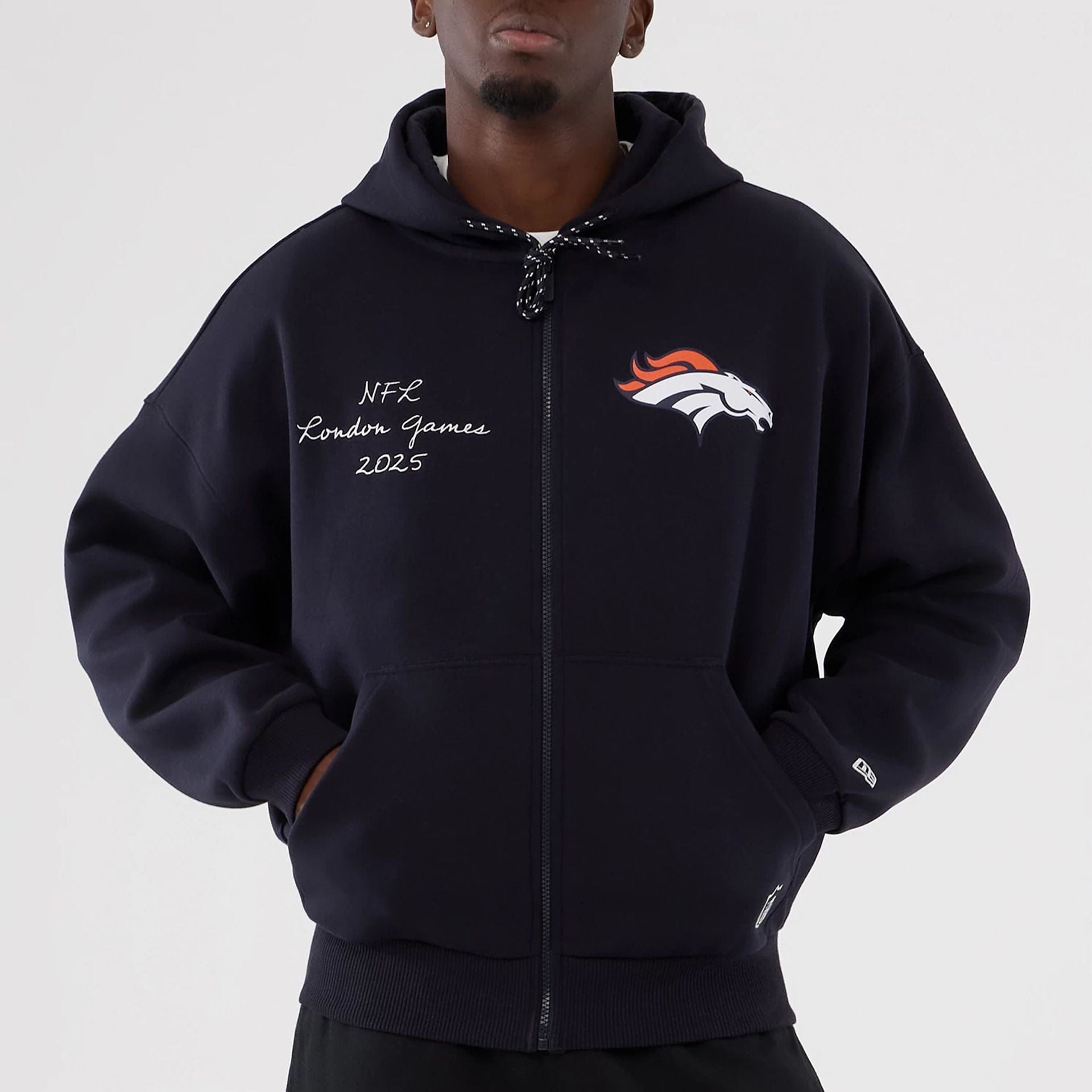 The Male model is wearing Denver Broncos NFL International Series Games 2025 Navy Premium Pullover Hoodie  5
