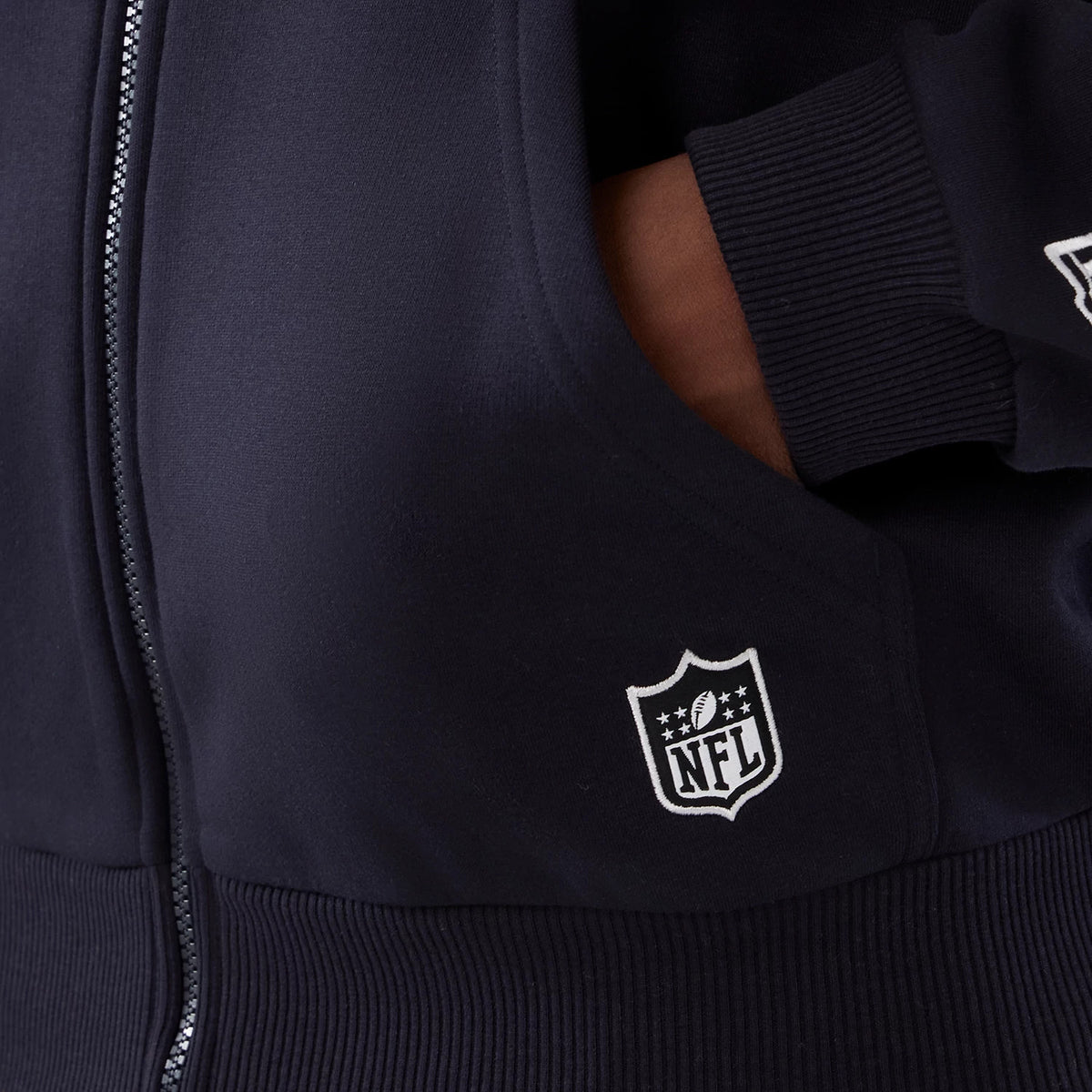 New Era Denver Broncos NFL International Series Games 2025 Navy Premium Pullover Hoodie, front view showing the ribbed cuffs and a white embroidered NFL logo on the lower left side above the waistband, with a zip along the front.