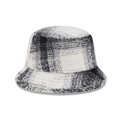 New Era White & Black Plaid Bucket Hat, front view showing the distinctive plaid pattern across the entire crown and visor, featuring a soft fabric texture and relaxed shape for casual styling.
