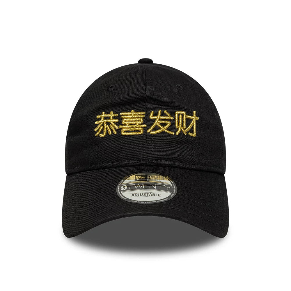New Era Lunar New Year Black 9TWENTY Adjustable Cap, front view showing gold embroidered Chinese calligraphy on the front panel, a pre-curved black visor, and the 9TWENTY size sticker centrally placed on the visor.