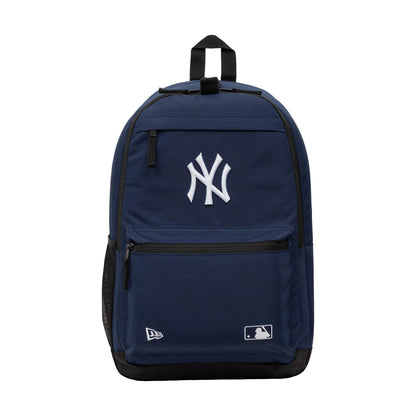 New Era New York Yankees MLB Navy Delaware Backpack, front view showing a large embroidered white NY logo at the centre of the navy backpack, a zip pocket at the front with embroidered New Era and MLB logos, and a black top handle.