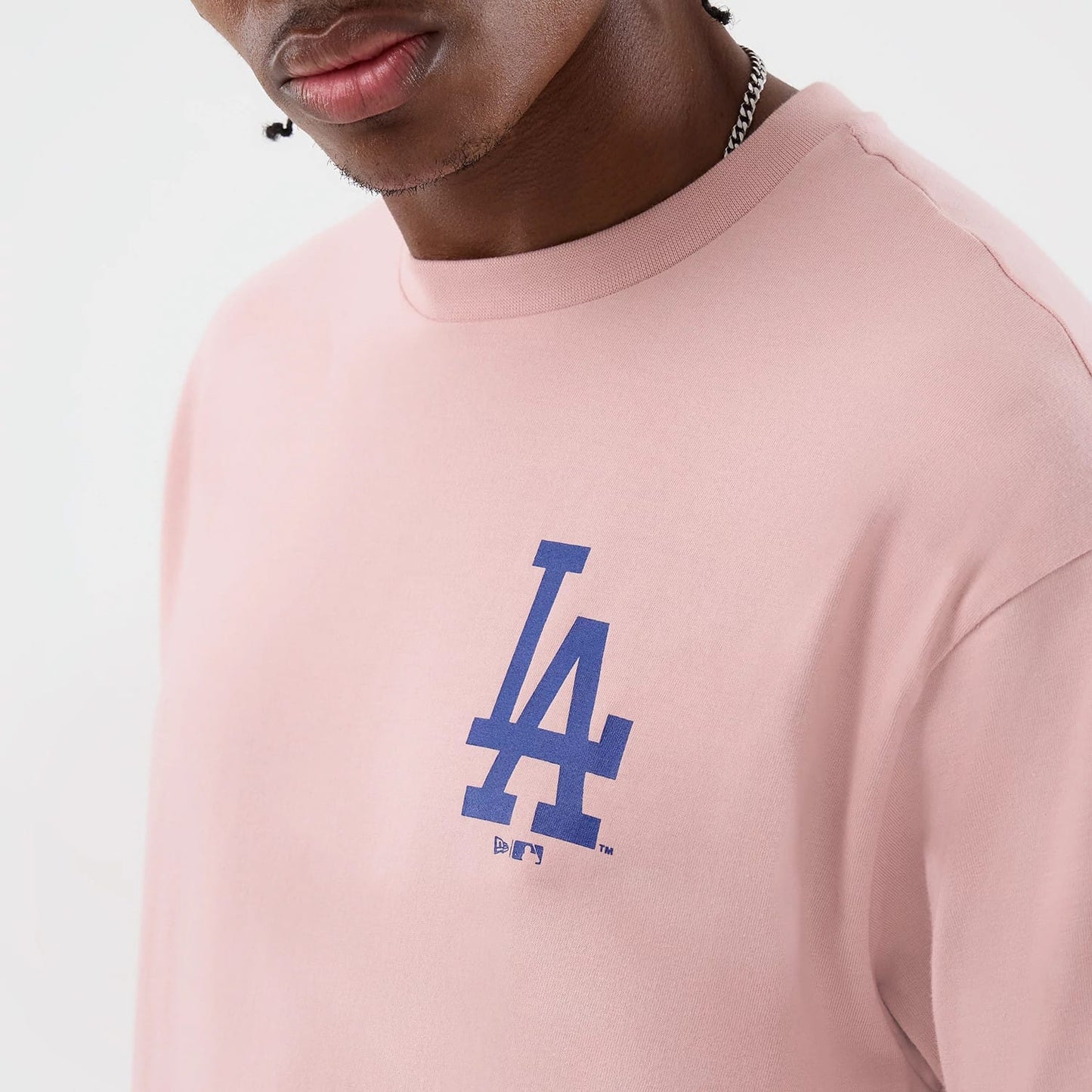 The model is wearing this MLB Cap Graphic LA Dodgers Oversized T-Shirt in pastel pink. 5