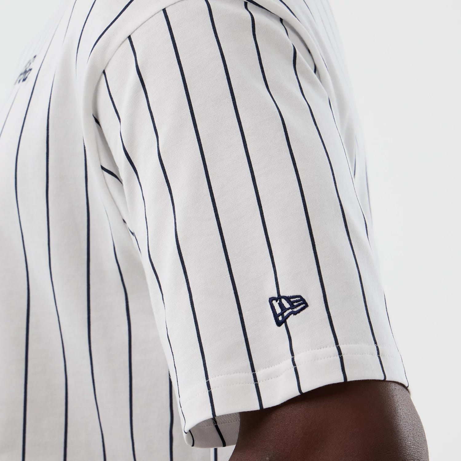 The model is wearing this New Era Pinstripe Oversized T-Shirt in Open White. 5