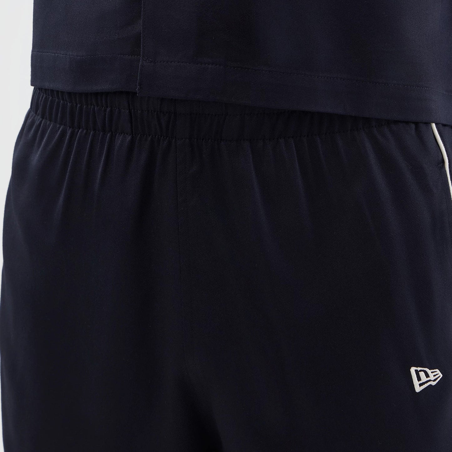 The model is wearing this New Era Piping Shorts in navy. 5