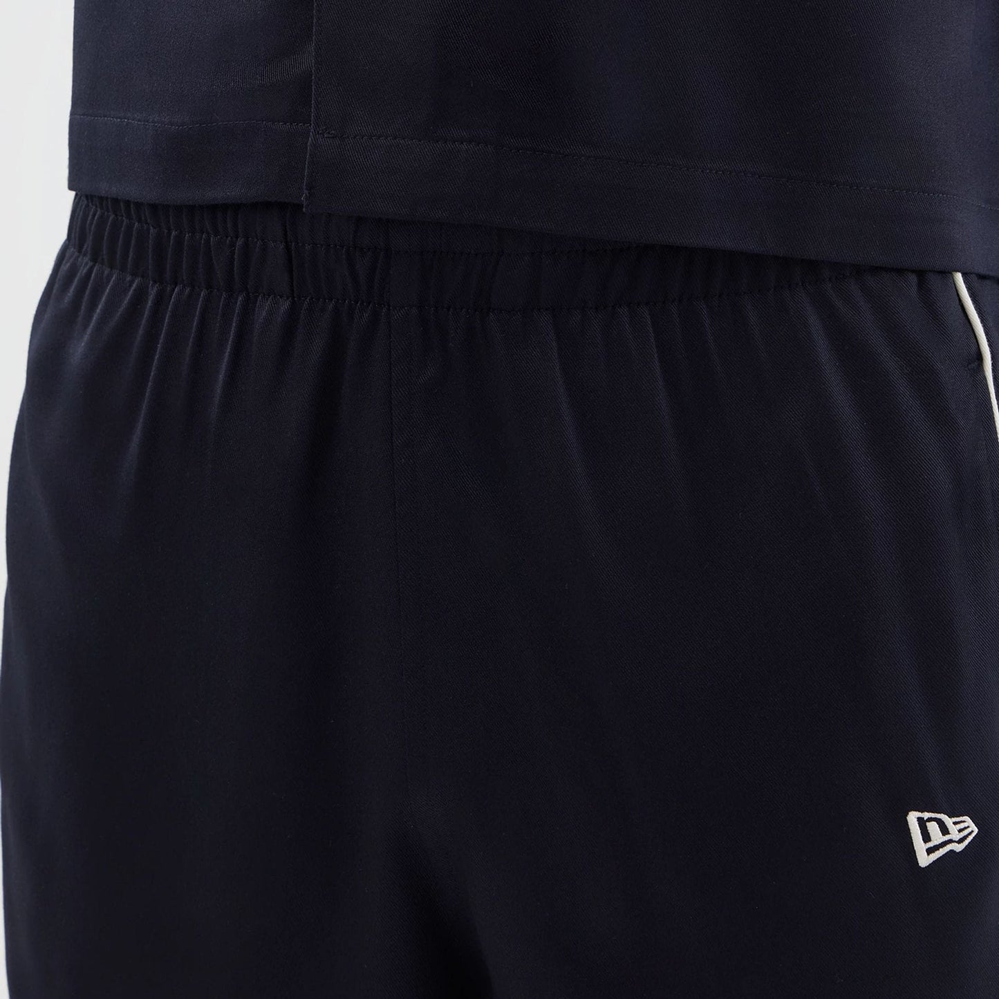 The model is wearing this New Era Piping Shorts in navy. 5