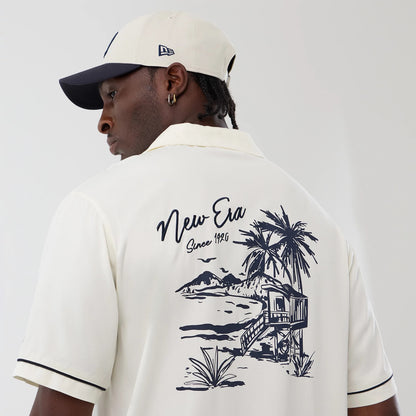 The model is wearing this New Era Graphic Revere Short Sleeve Shirt in open white. 4