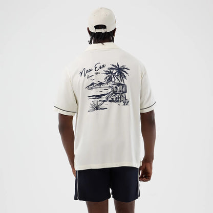 The model is wearing this New Era Graphic Revere Short Sleeve Shirt in open white. 2