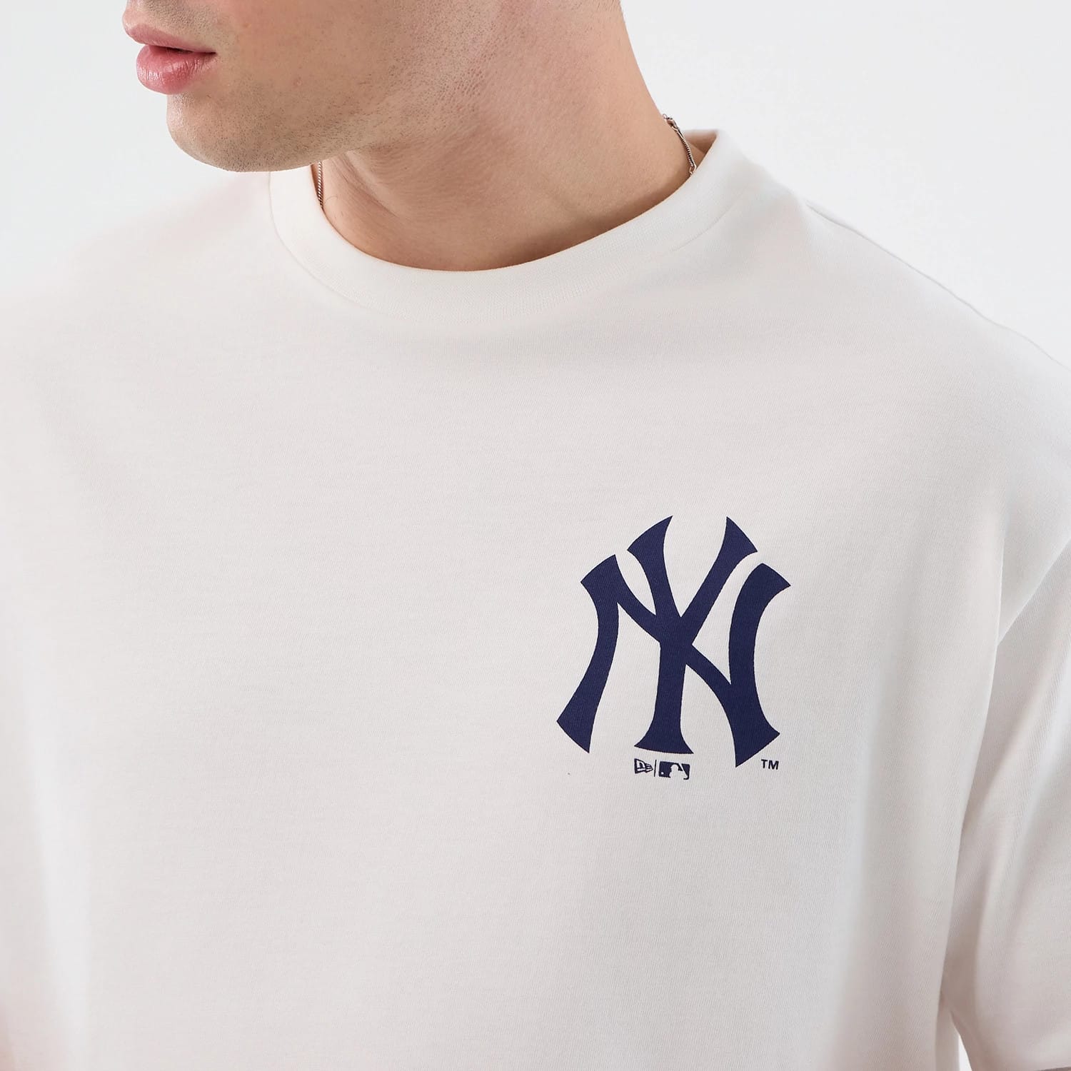The model is wearing this MLB Cap Graphic New York Yankees Oversized T-Shirt in white. 6
