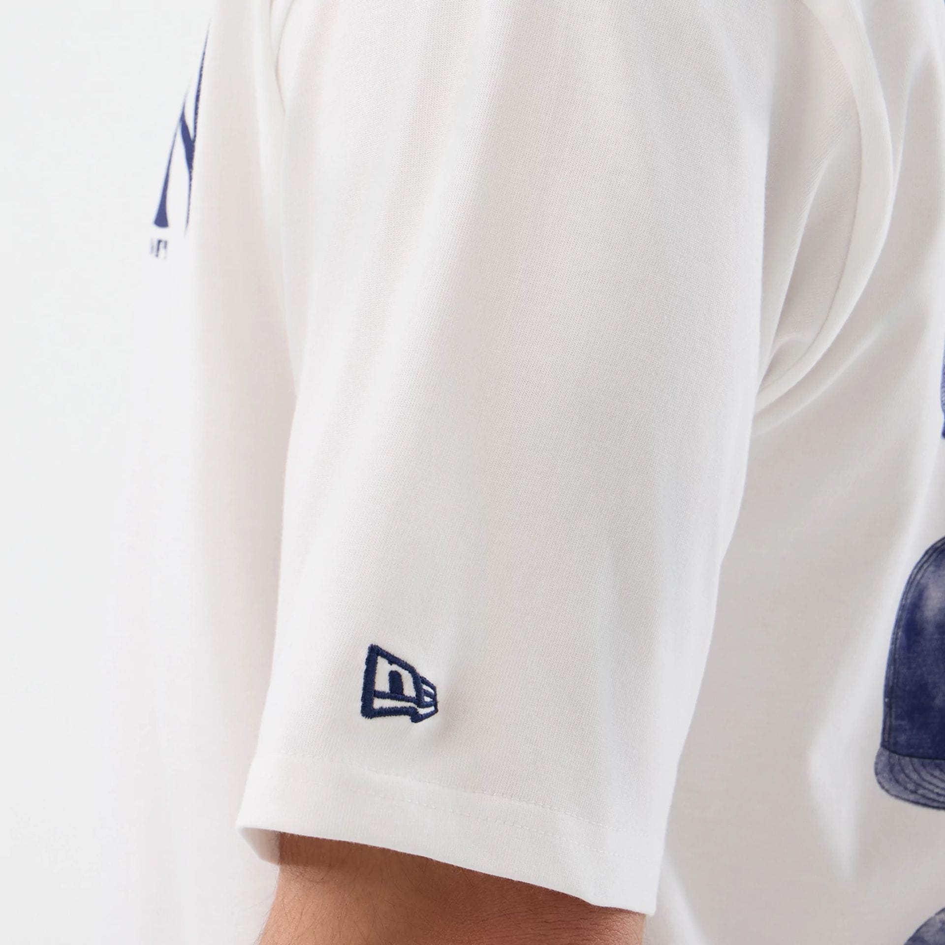 The model is wearing this MLB Cap Graphic New York Yankees Oversized T-Shirt in white. 8