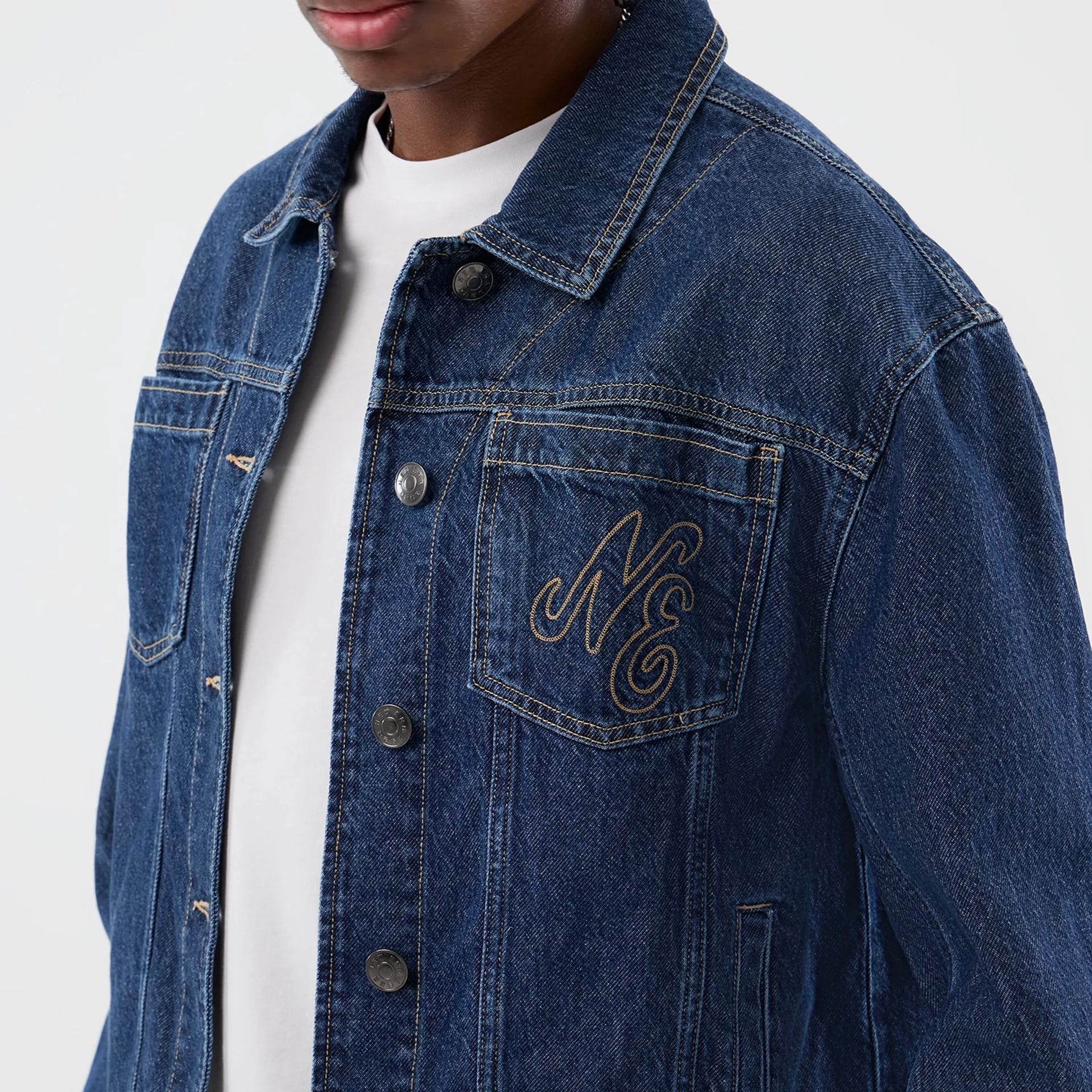 The model is wearing this New Era Script Denim Jacket in dark blue. 5