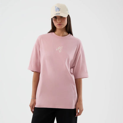 The model is wearing this New Era Floral Graphic Oversized T-Shirt in pastel pink. 4