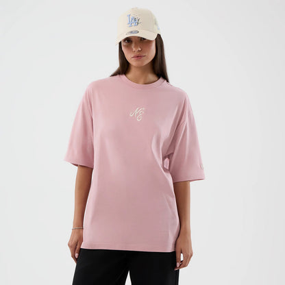 The model is wearing this New Era Floral Graphic Oversized T-Shirt in pastel pink. 4