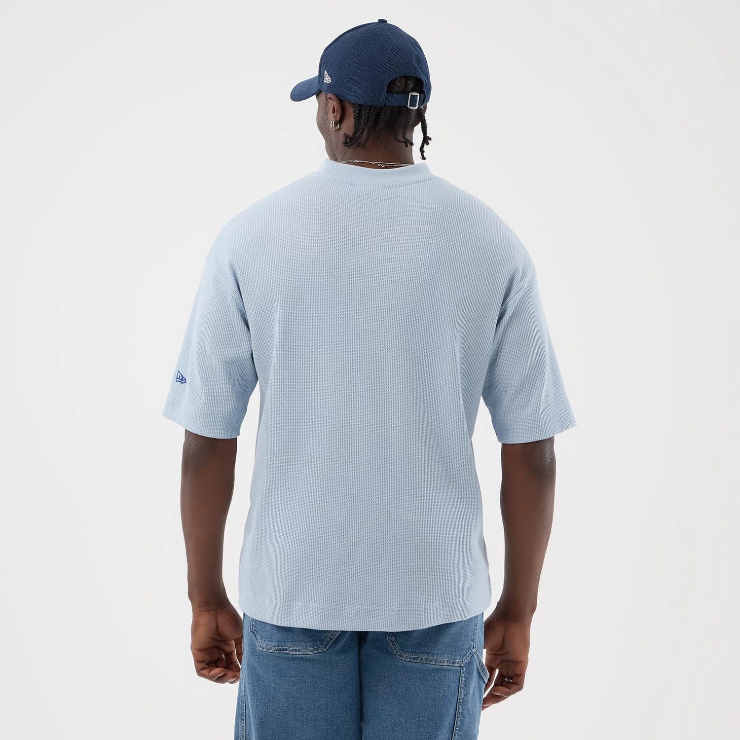 New Era LA Dodgers MLB Waffle Pastel Blue T-Shirt, back view on a model with a blue cap, showcasing the waffle texture of the pastel blue fabric, featuring a small blue embroidered New Era logo on the left sleeve near the hem.