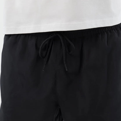 The model is wearing this New Era Swimming Shorts in black. 7